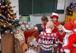 Dzieci cieszą się z prezentów znalezionych pod choinką